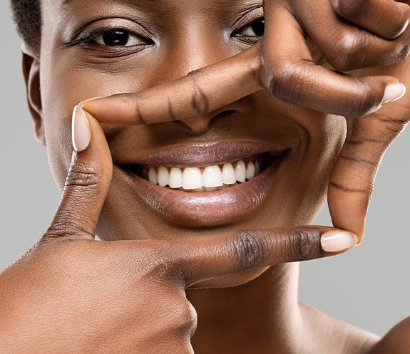 Woman framing her smile with 4 fingers