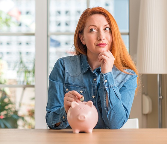 Woman putting a coin in a piggy bank